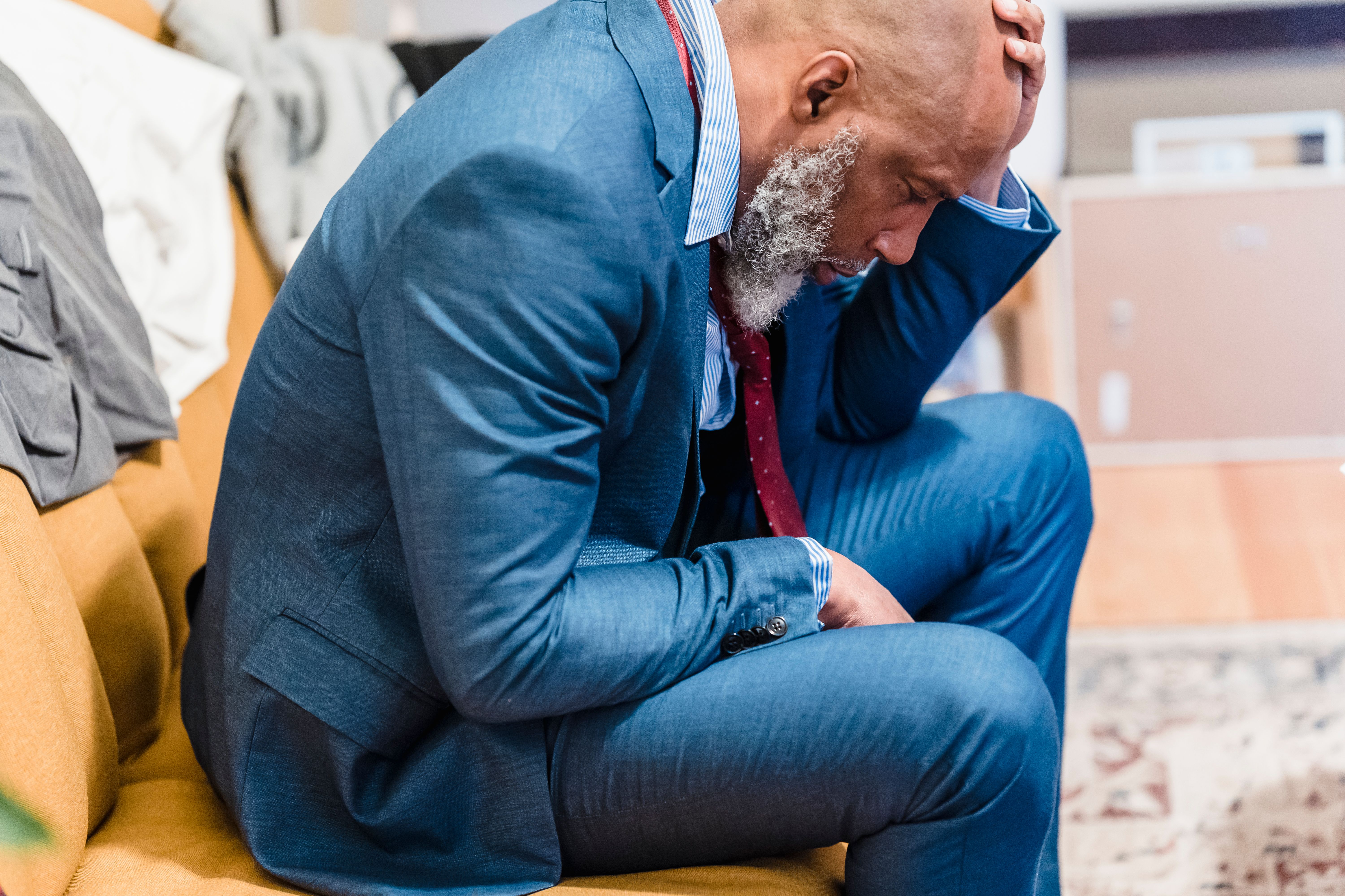 Stressed businessman in a suit sitting under pressure from investors