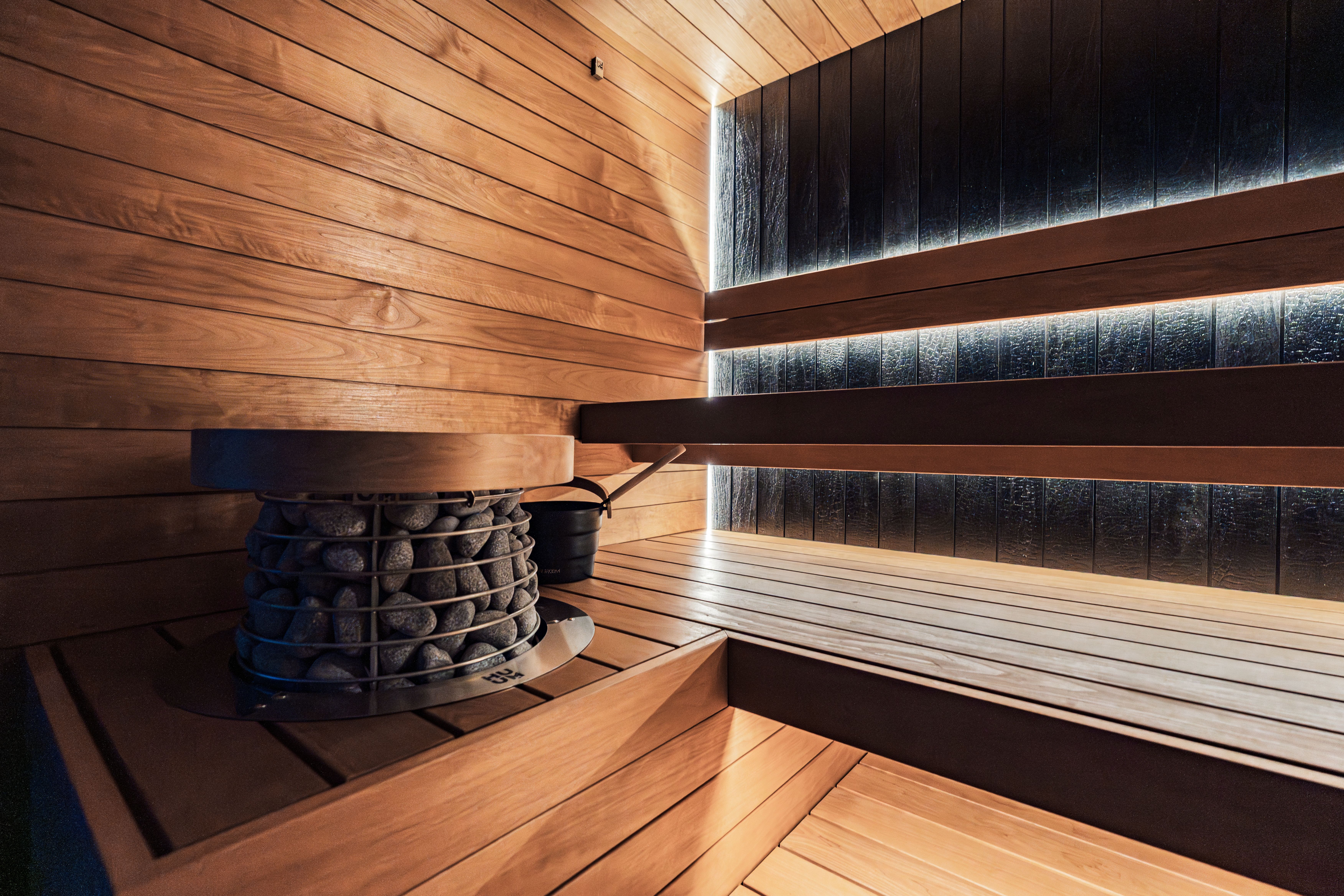 Modern wood-paneled sauna with a premium heater, suited to an upscale alpine wellness retreat.
