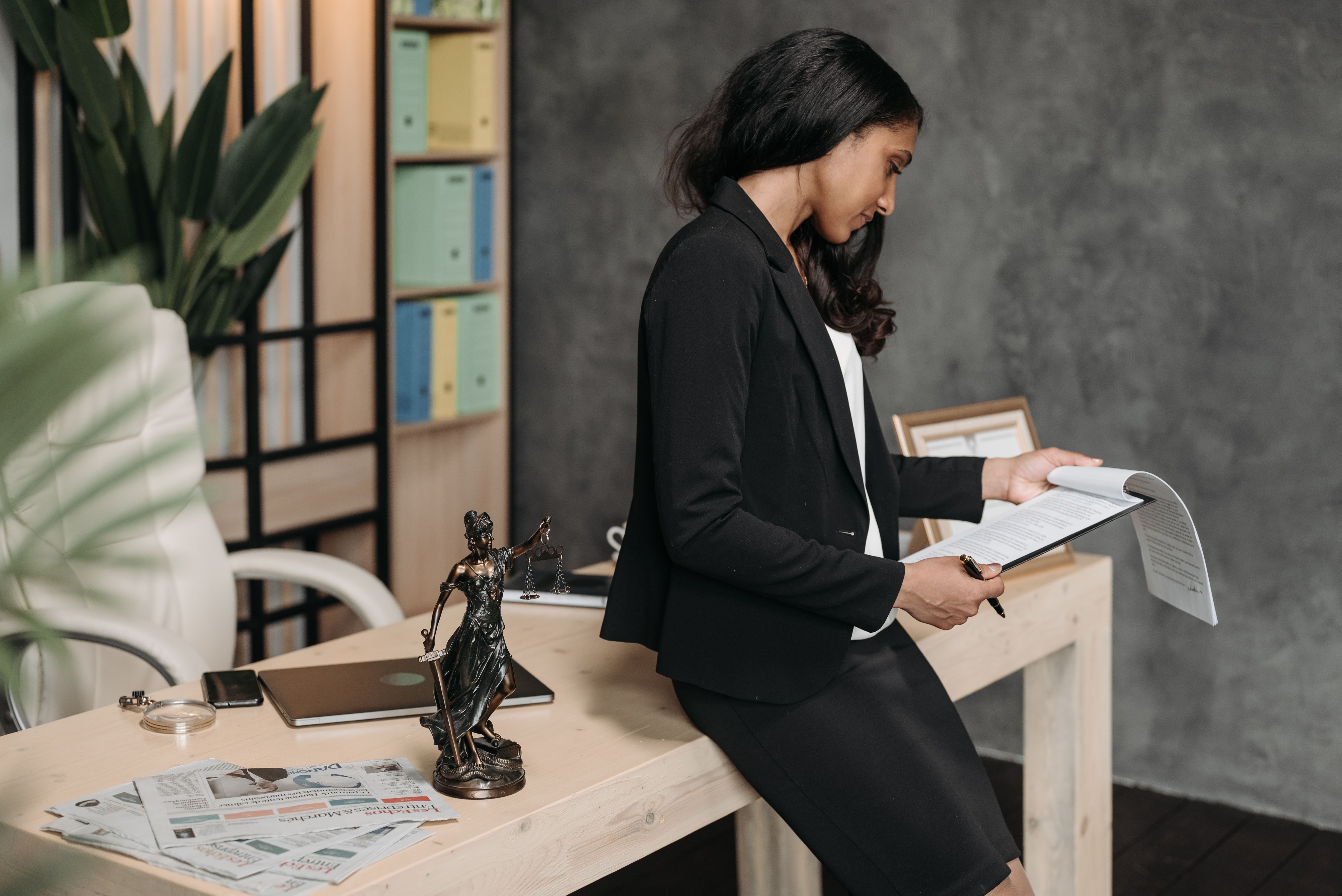 Lawyer in a business suit reviewing legal documents at her office desk