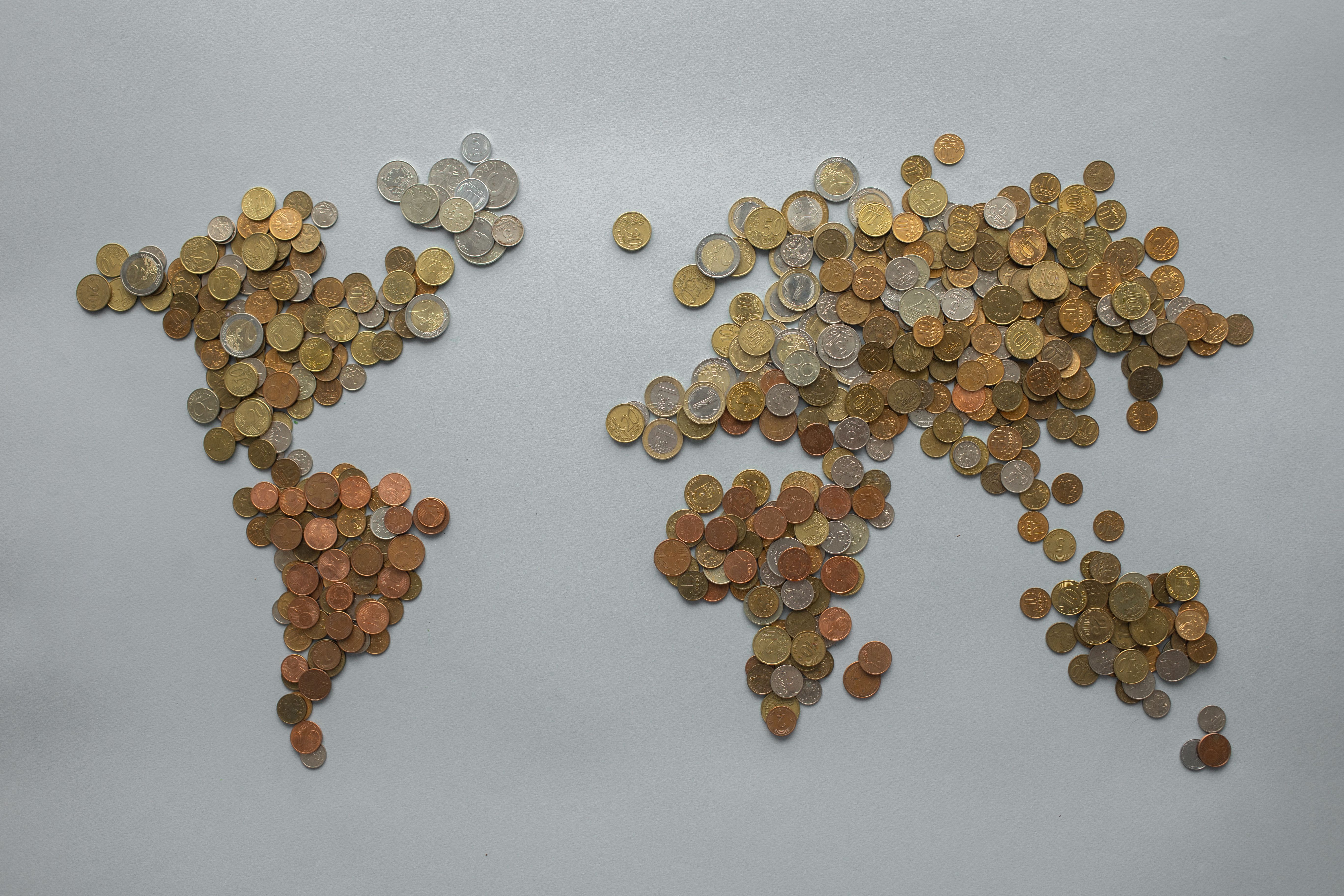 World map made of coins on a gray backdrop, symbolizing global finance and investment