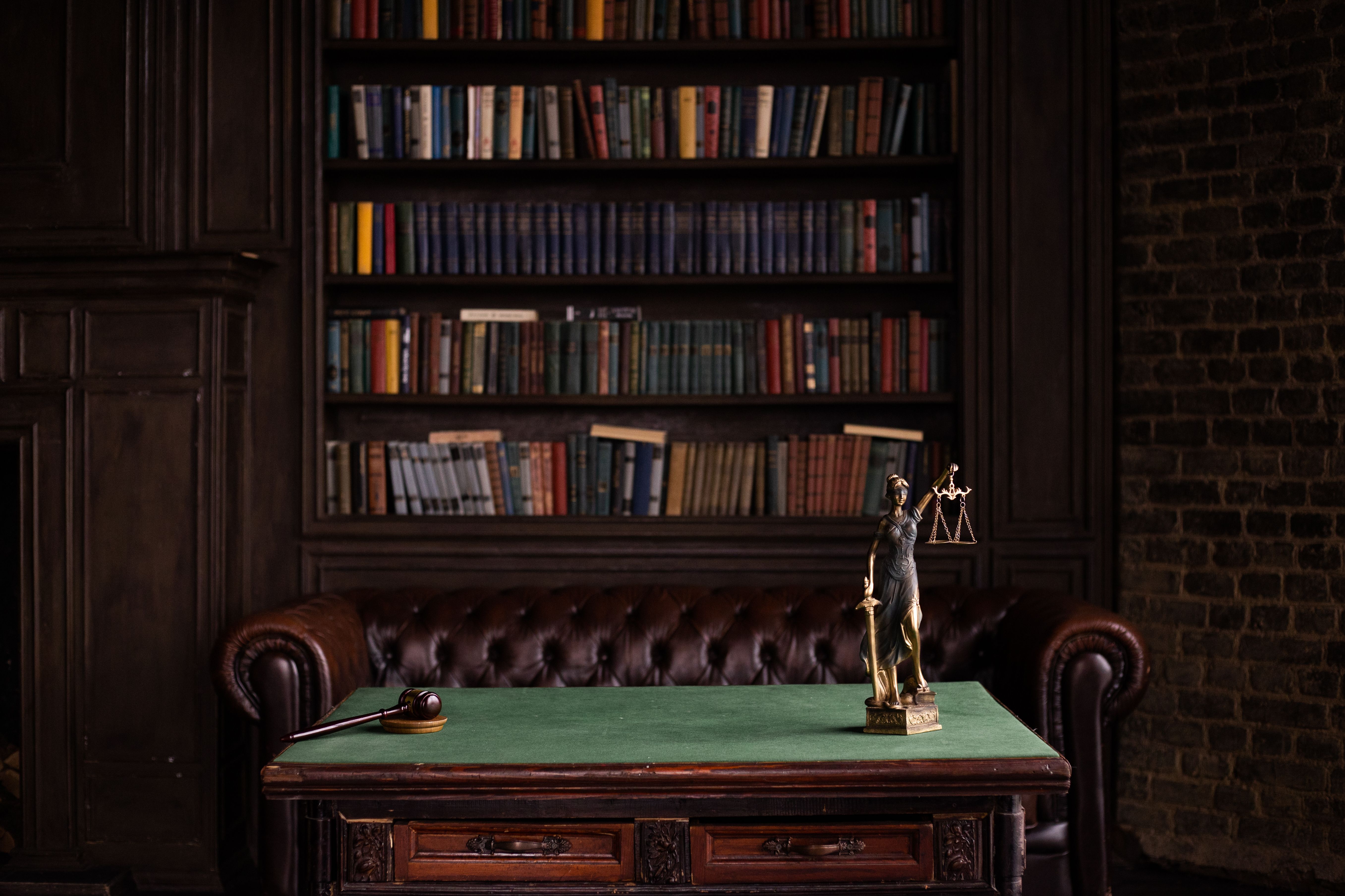 Classic law library with shelves of books, a gavel, and a Lady Justice figurine
