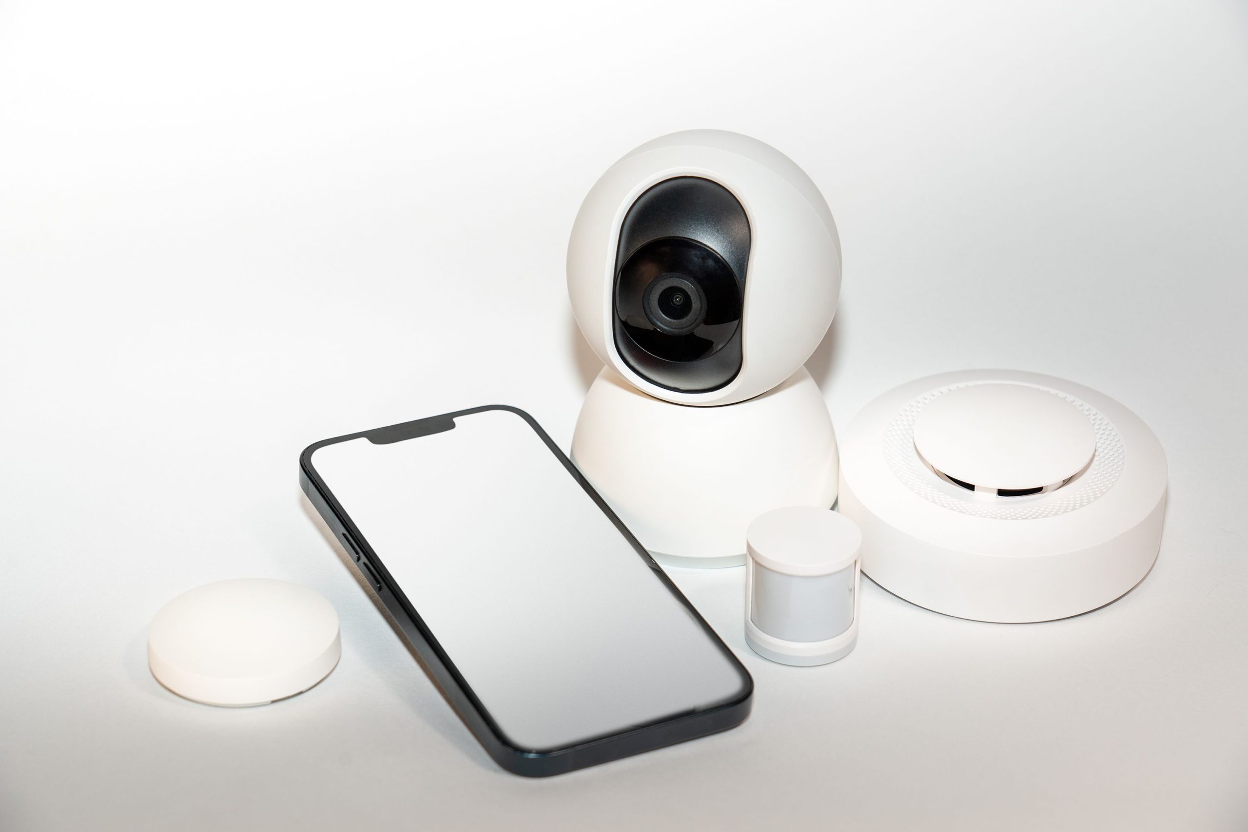 smart-home-security-gadgets-smartphone Collection of smart home security gadgets with a smartphone display.
