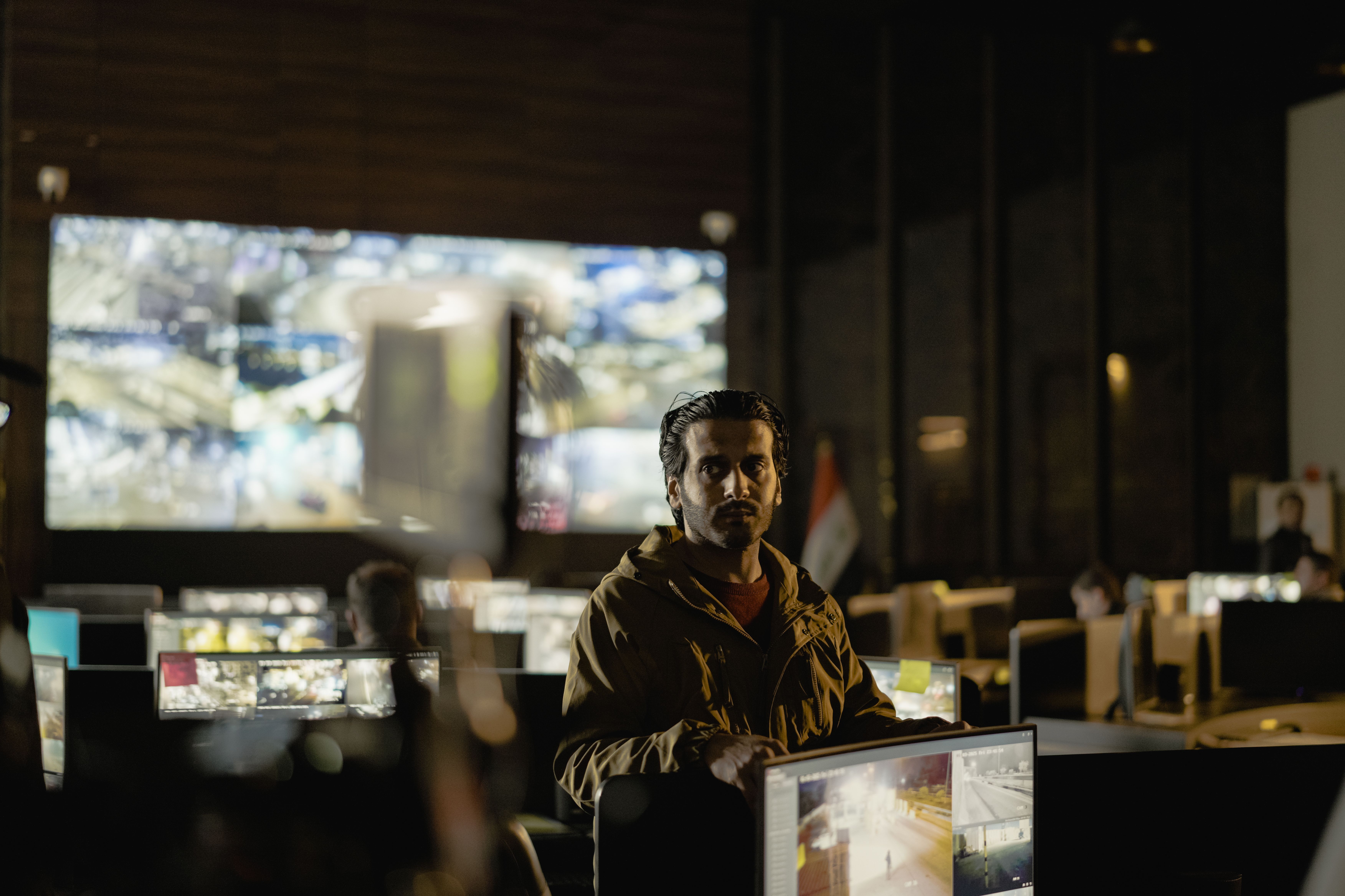 Diverse security analysts collaborating in a modern SOC control room with live monitoring feeds